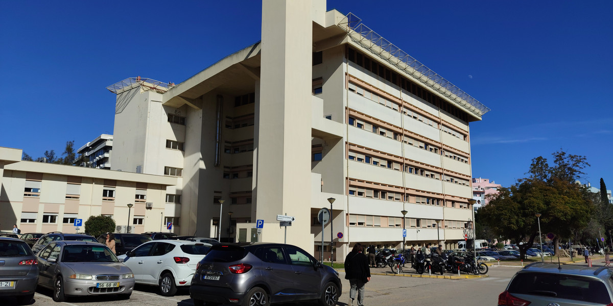 Modern hospital building with brutalist architecture and parking lot in Portugal under blue sky